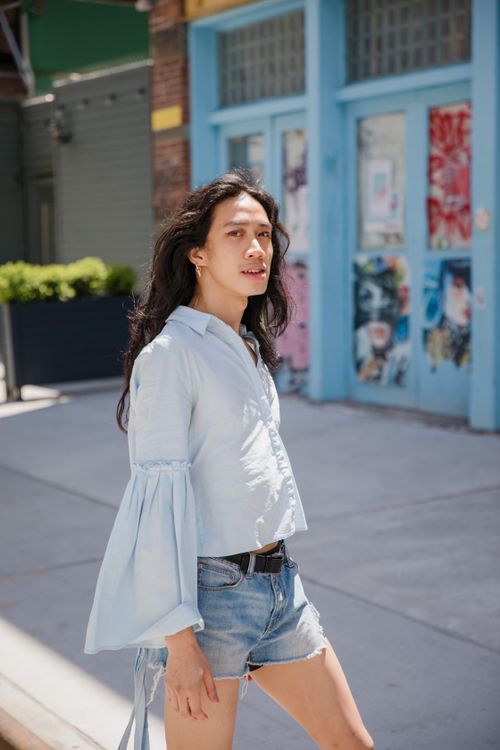 Free Stylish woman wearing denim shorts and white blouse on a sunny day in the city. Stock Photo