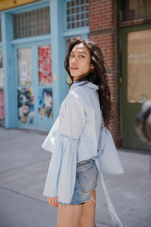 Free Stylish woman in denim and long sleeves poses on a sunny urban street. Stock Photo