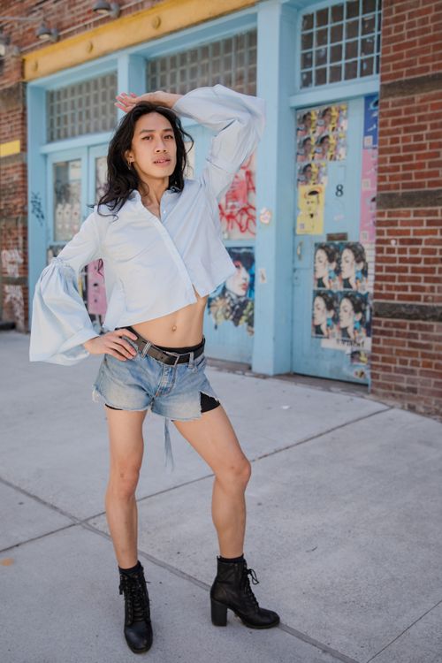 Free Model posing stylishly in denim shorts and boots against an urban backdrop. Stock Photo