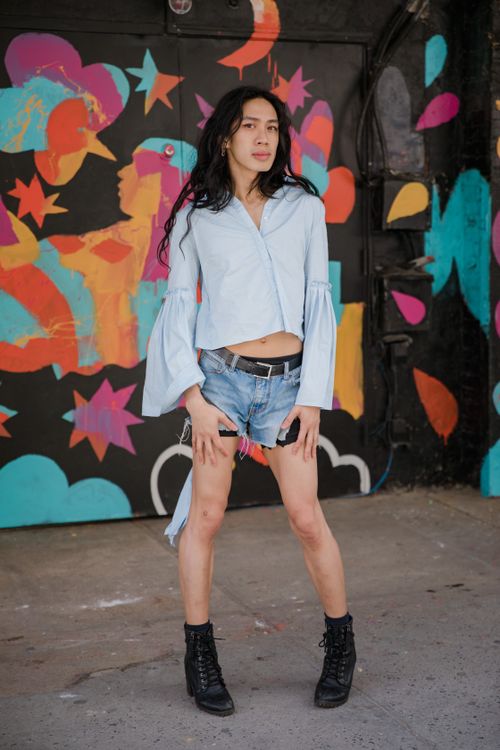Free Trendy woman posing confidently in front of vibrant street art wearing a stylish outfit. Stock Photo