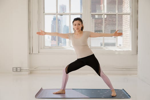 Asian woman doing yoga in bright indoor studio, promoting fitness and wellness.