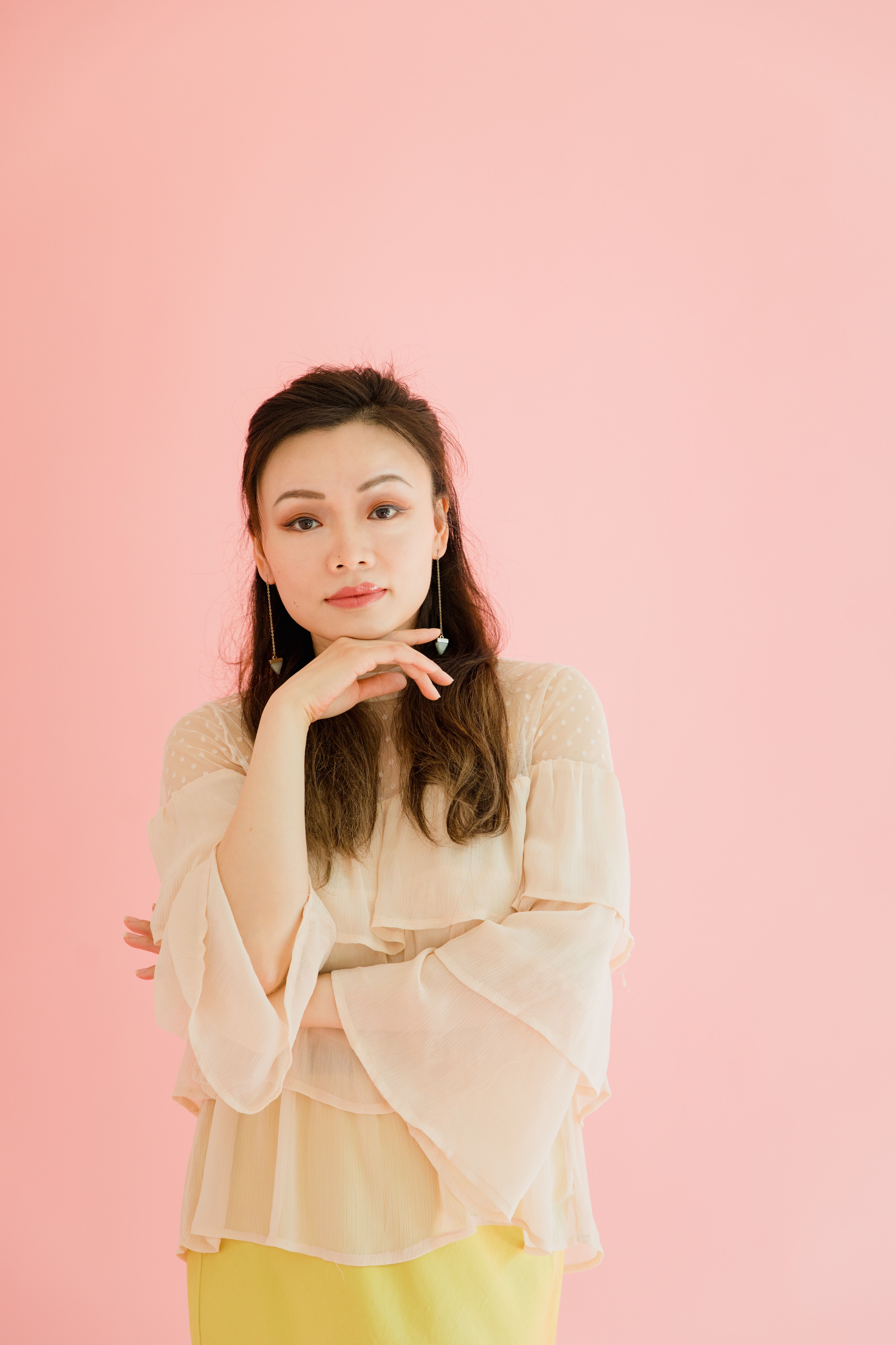 A Woman in Beige Long Sleeves with Her Hand on Her Chin · Free Stock Photo