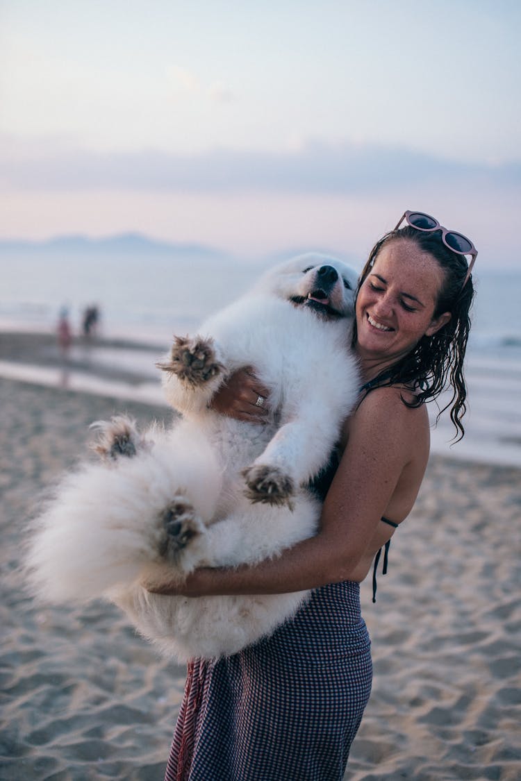 A Woman Carrying A Dog