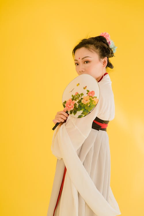 Gratis lagerfoto af asiatisk kvinde, bindi, gul baggrund