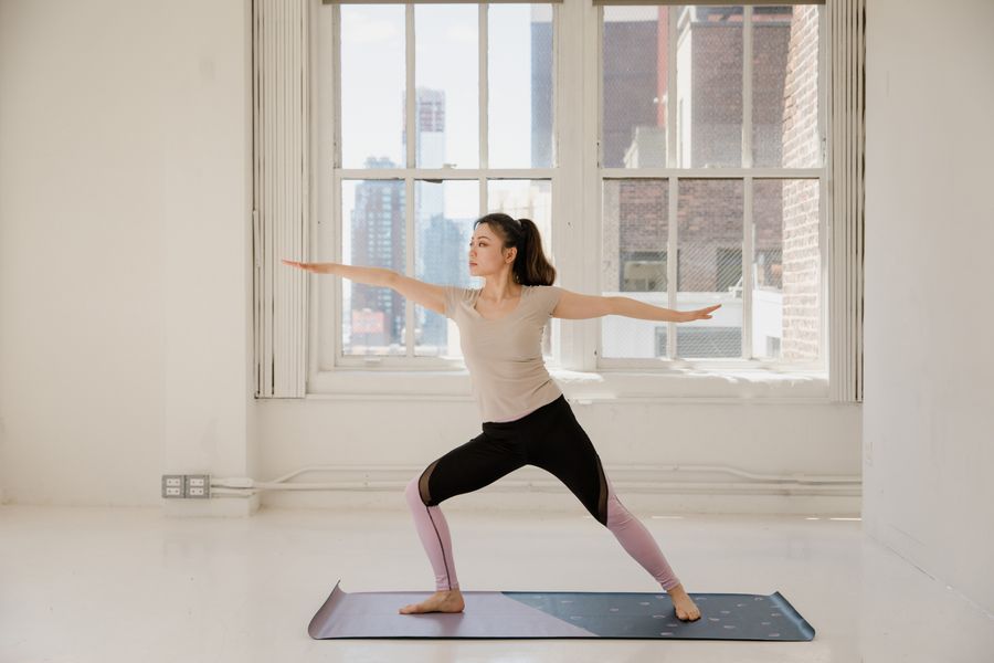 Coach holding a standing warm-up pose in a daylit loft studio - photo by RDNE Stock project on Pexels