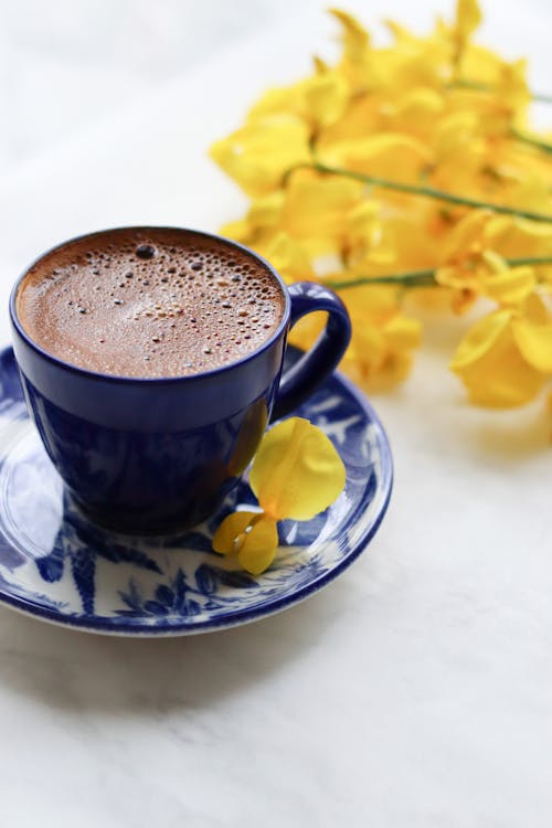 Free Delicious coffee in cup near flowers Stock Photo