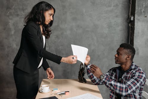 A Woman Handing a Man a Contract