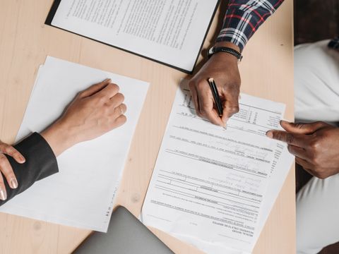 Two people reviewing paperwork at an office desk