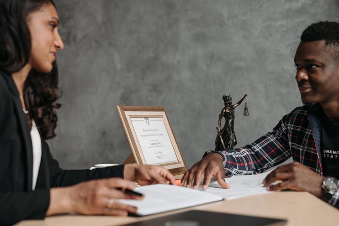 Two professionals engaged in a discussion over legal documents in an office setting