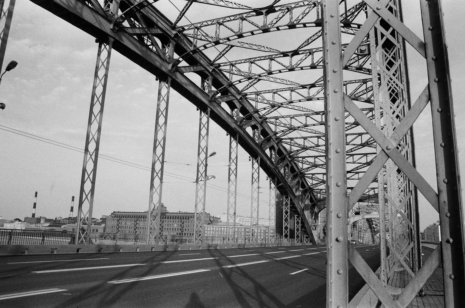 Black and white photo of a steel truss bridge showcasing its intricate design.