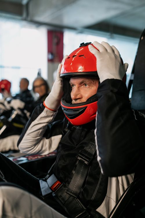Free A senior man wearing a helmet gets ready for an indoor go-karting race. Stock Photo