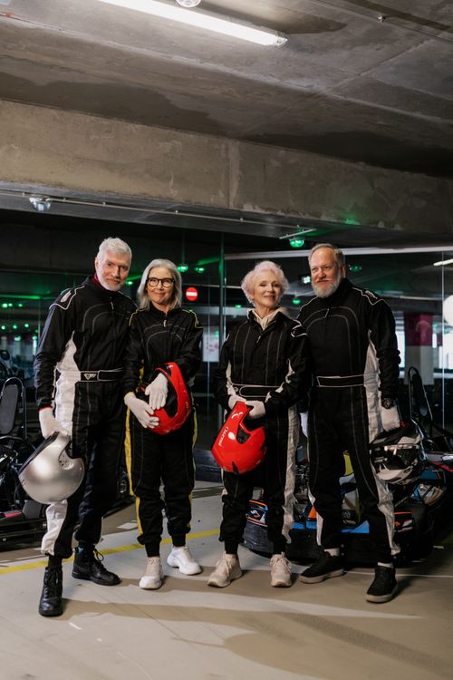 Free A group of senior adults in racing suits posing at an indoor karting track. Stock Photo