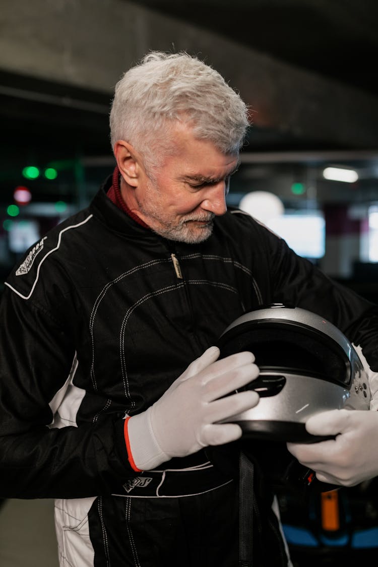 Bearded Man In Racing Suit Holding A Helmet