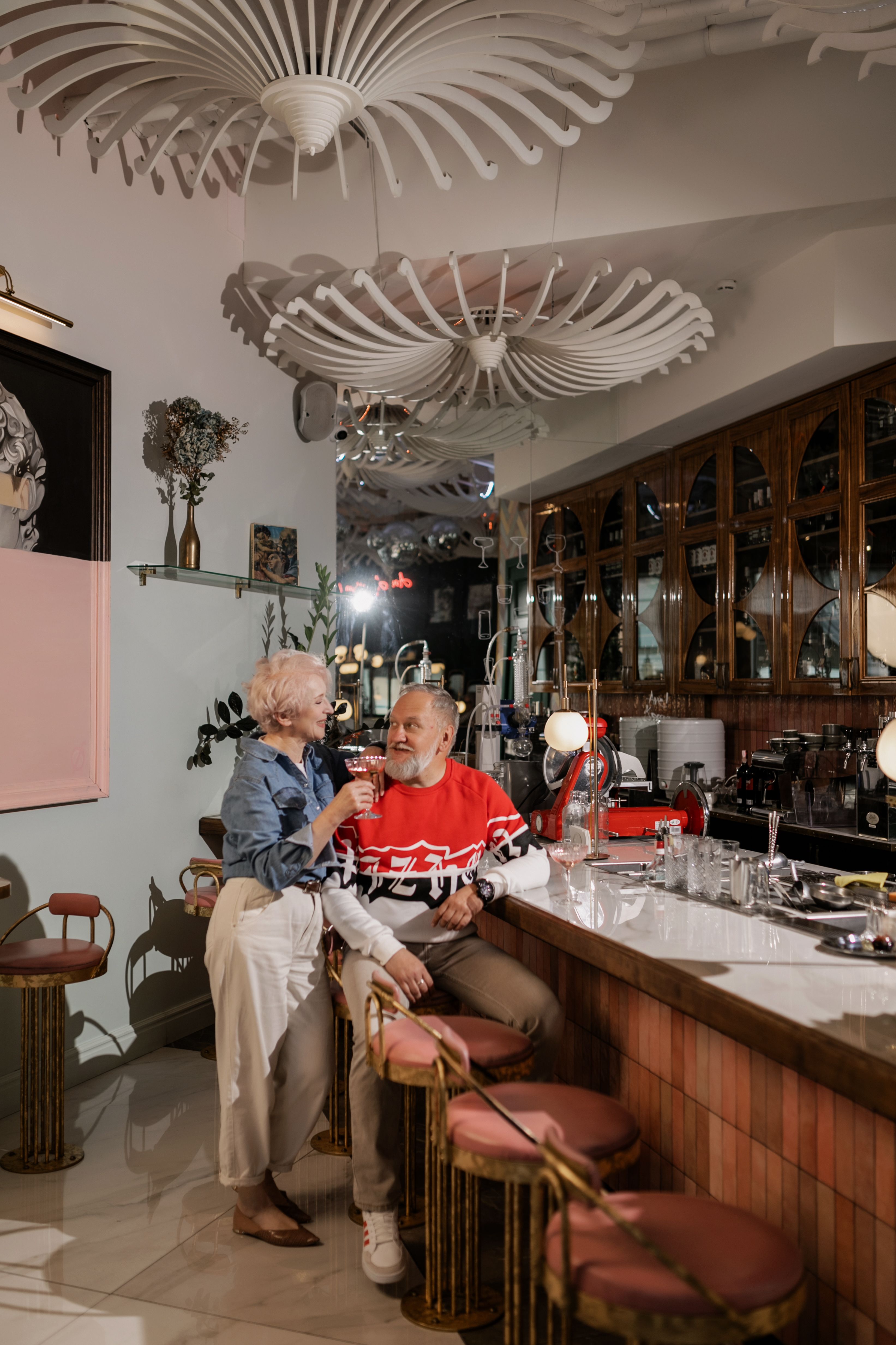 Senior couple shares a joyful moment at a stylish café, embodying love and togetherness.