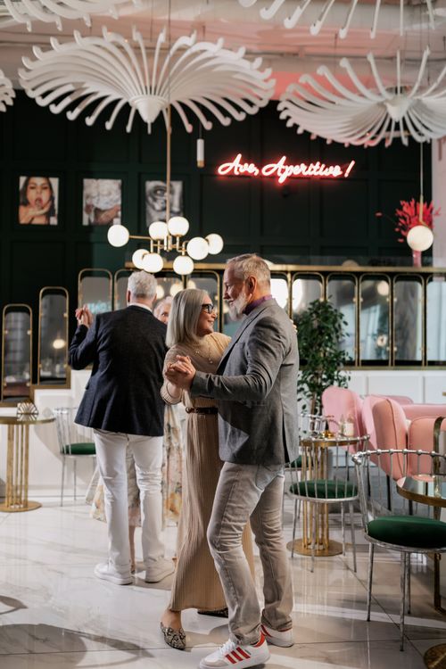 Free Senior couple enjoying a graceful dance in a stylish, contemporary restaurant setting. Stock Photo