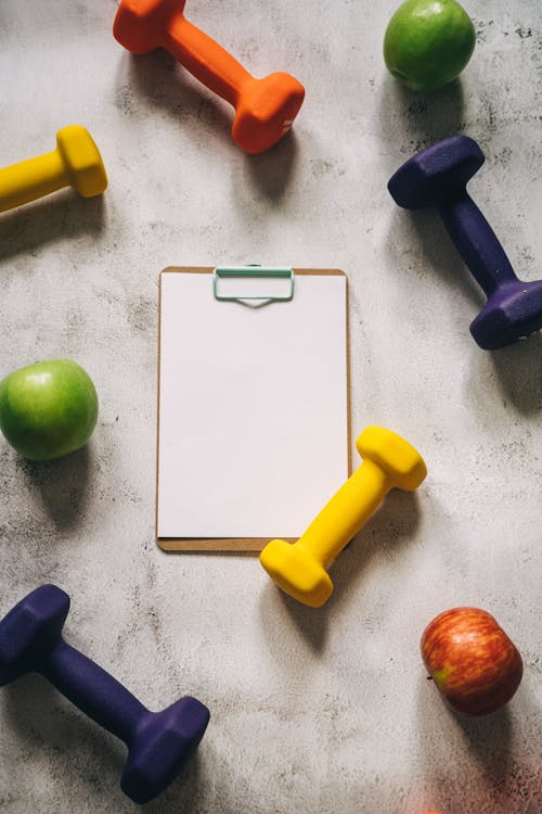 Free Colored Dumbbells Around Fruits and Clipboard Stock Photo