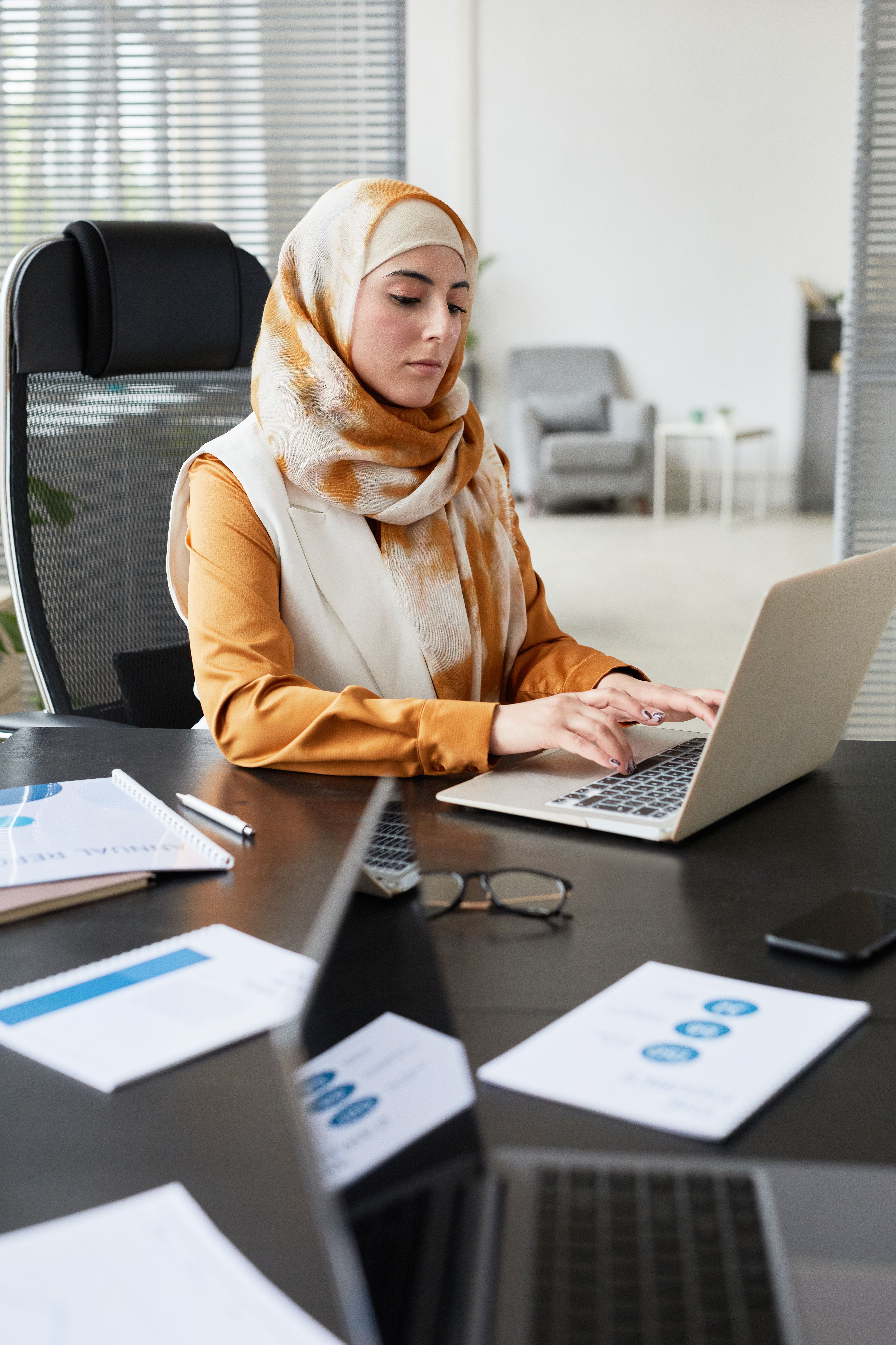 A marketer working on a laptop in a bright office
