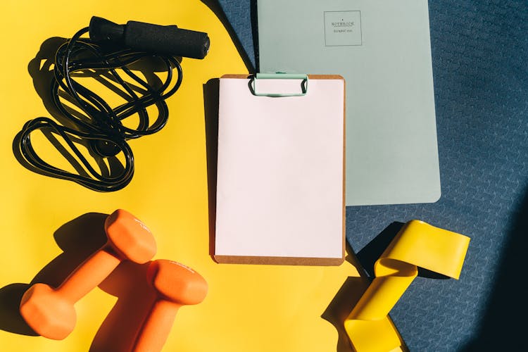 A Flatlay Of Gym Equipment And Papers