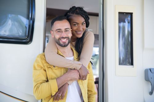 Free Happy couple enjoying a moment together at their campervan, showcasing love and adventure. Stock Photo