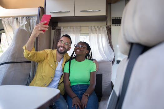 Happy couple taking a selfie inside a cozy camper van, smiling and enjoying their travel adventure.