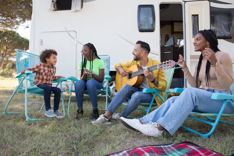 A Family Sitting Beside The Caravan