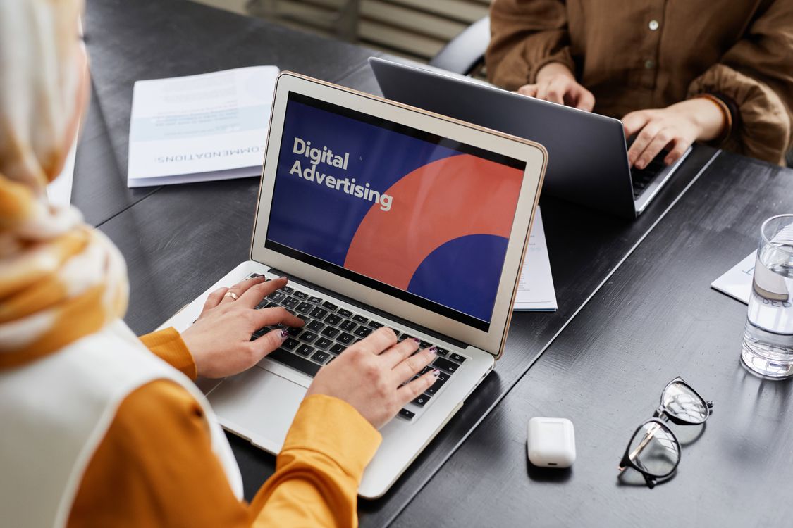 Dua profesional bekerja pada laptop untuk kampanye digital advertising