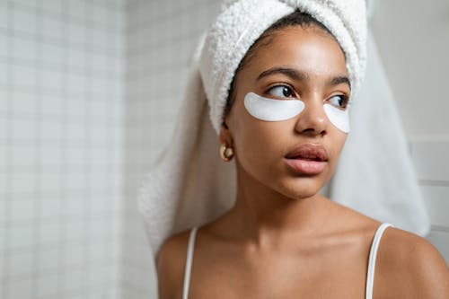 Woman With White Towel on Head And Under Eye Masks