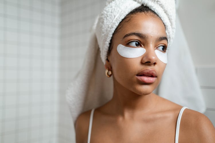 Woman With White Towel On Head And Under Eye Masks