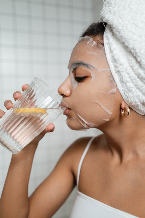 Woman Drinking Water from Clear Drinking Glass