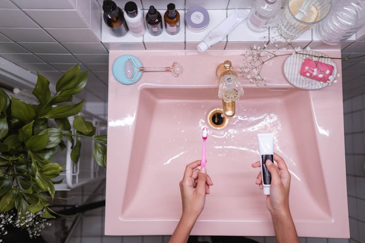 Person Holding Pink Toothbrush 