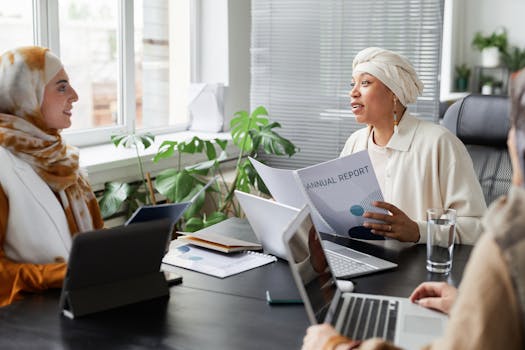 Businesswomen discussing an annual report in a modern office setting.