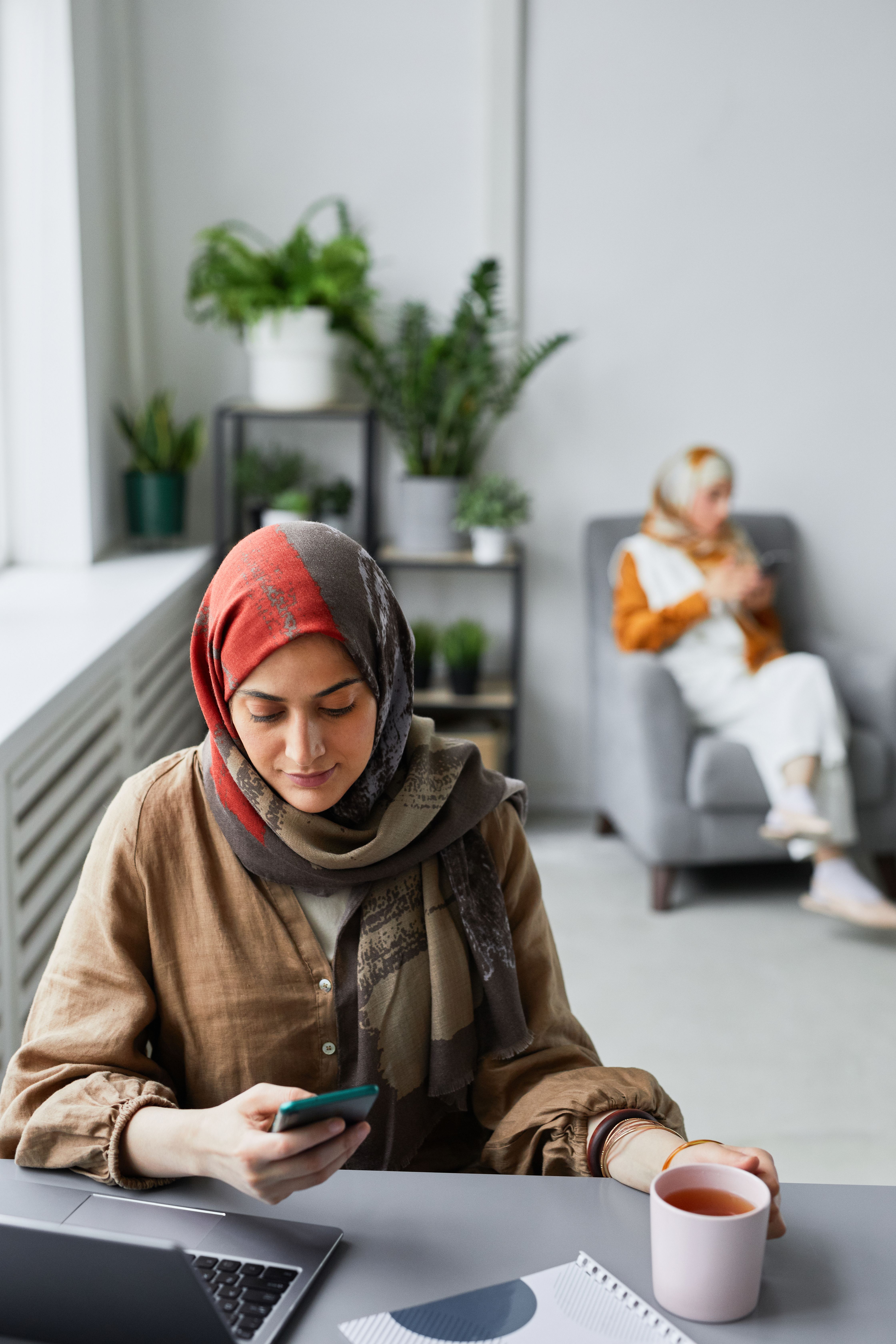 A Woman Wearing a Hijab Using a Smartphone · Free Stock Photo