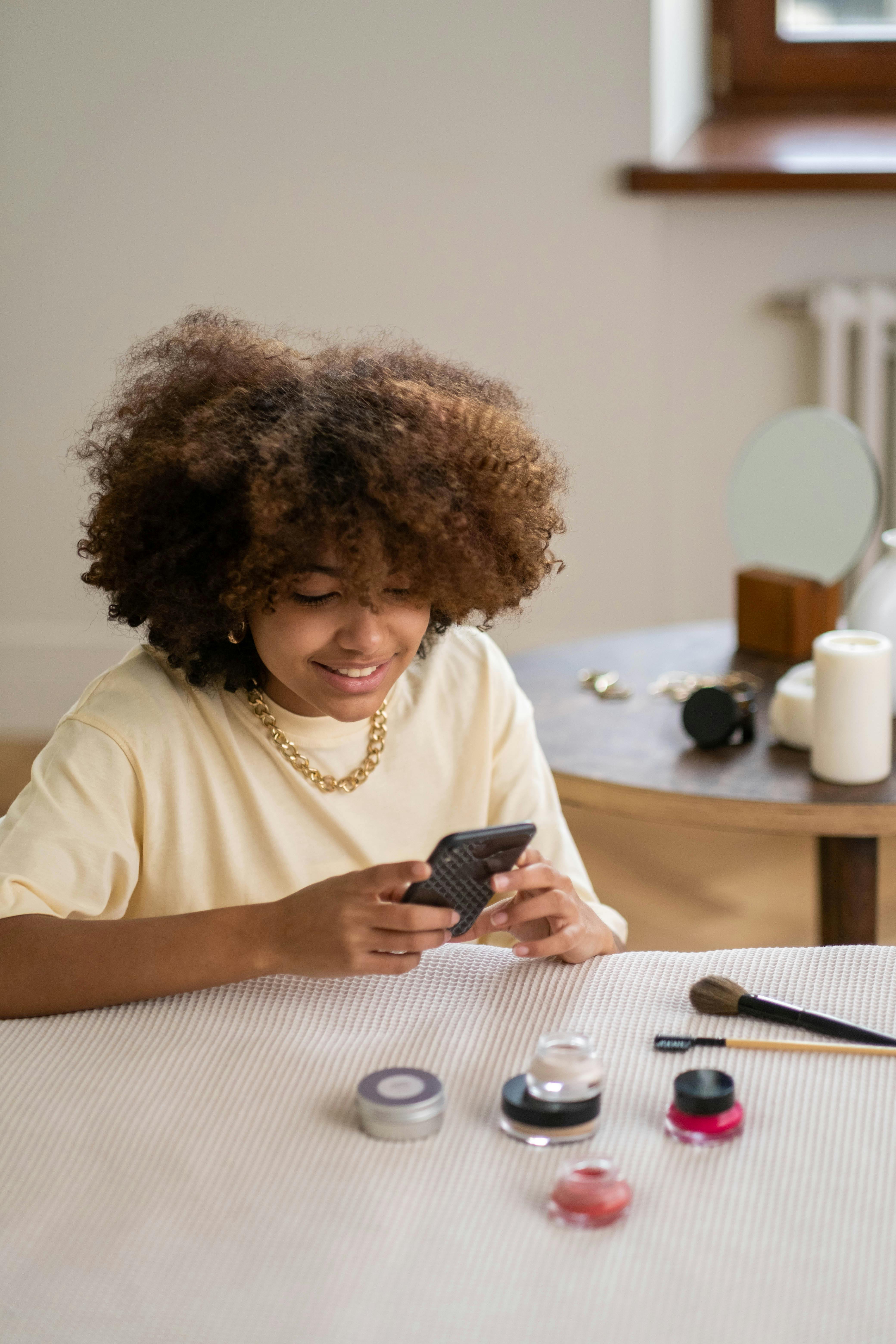 woman in yellow shirt holding black smartphone