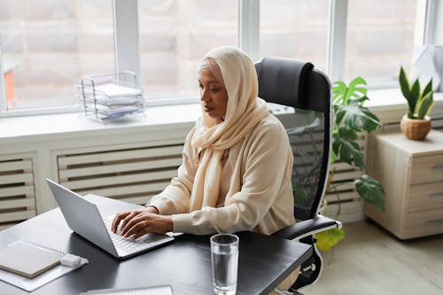 A Woman Typing on Her Laptop