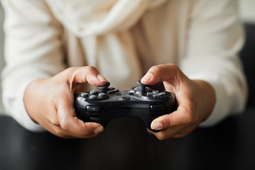 Close-up of a person holding a video game controller, focusing on hand interaction.