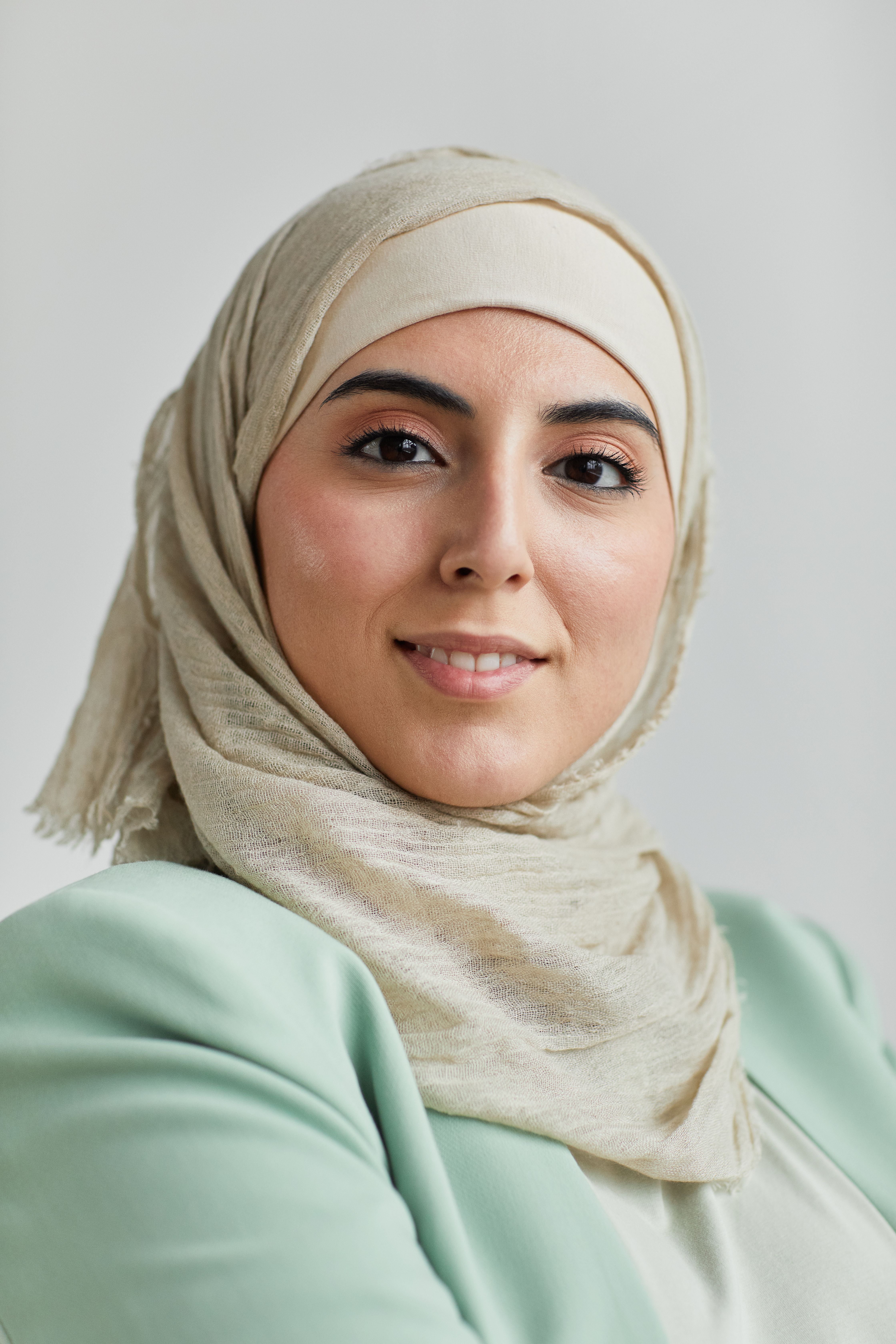 Elegant portrait of a woman in hijab with a gentle smile, exemplifying grace and confidence.