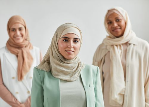 Free Portrait of three diverse women in hijabs smiling, symbolizing unity and cultural diversity. Stock Photo