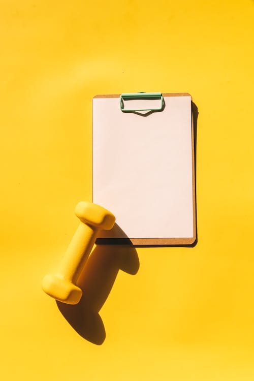 Free Overhead Shot of a Dumbbell and a Clipboard Stock Photo