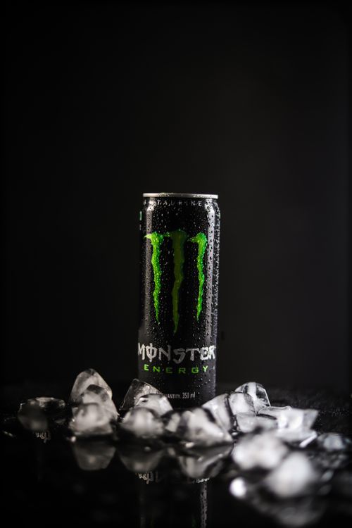 Free Vibrant energy drink can surrounded by ice cubes, with a sleek black background. Stock Photo