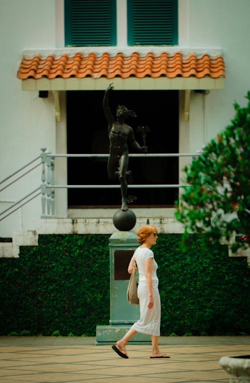 Mulher Andando Na Frente Da Estátua