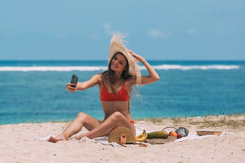 Free A Woman Taking a Selfie at the Beach Stock Photo