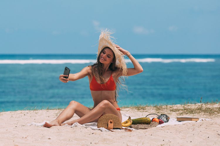 A Woman Taking A Selfie At The Beach