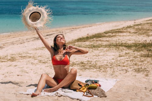 Free Woman Holding a Hat at the Beach Stock Photo