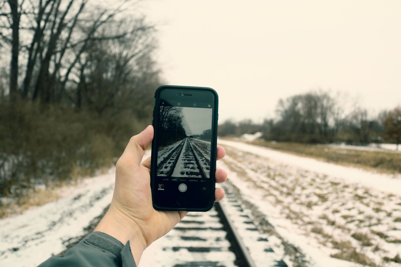 A phone photographing railway tracks in winter