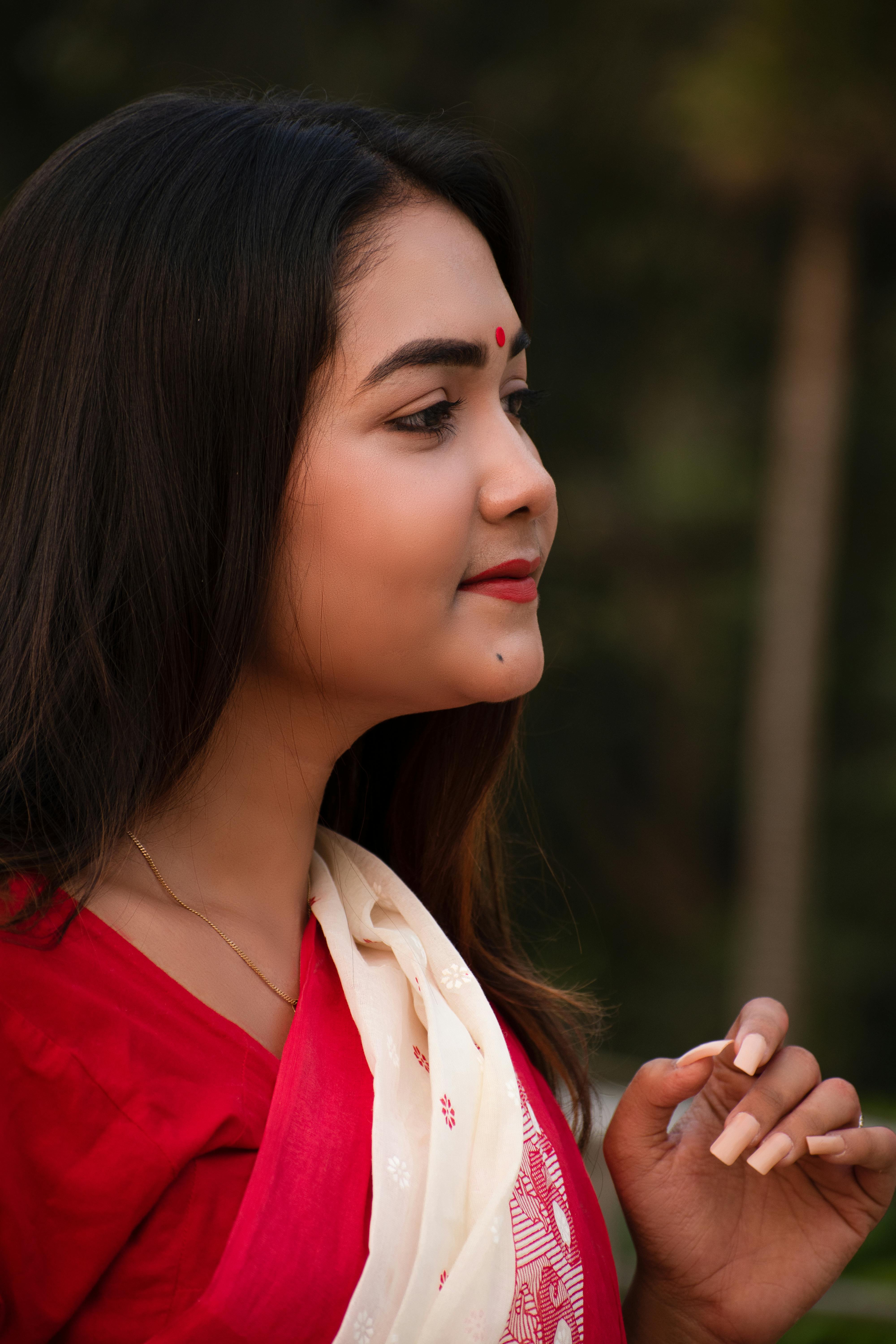 Profile of a South Asian woman in traditional attire with bindi, captured outdoors.
