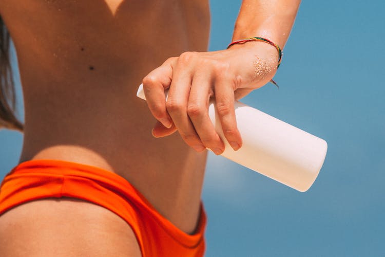 A Woman Holding A Bottle Of Spray