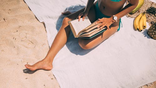 Free A Woman in Blue Bikini Sitting on Sand Stock Photo