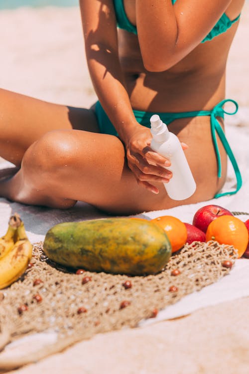 Free A Woman in Green Bikini Holding White Plastic Bottle Stock Photo