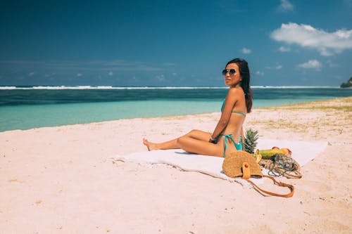 Woman Wearing Bikini Sitting on Shore