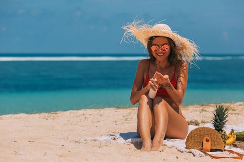 Free A Woman in the Beach Using a Sun Screen Product Stock Photo